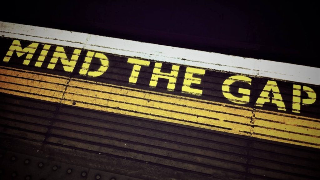 Picture of the yellow line and words "MIND THE GAP" seen in many train stations, particularly in the UK.