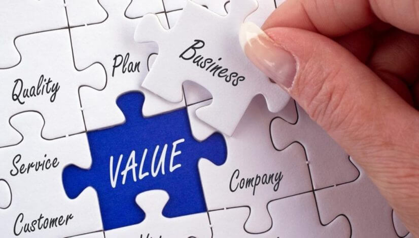 Zoomed in on a white puzzle with a word on each piece. The words are quality, plan, company, service, and content. One piece is being held above the puzzle and says "Business" while the empty space is a different color and says in larger letters "Value".
Defining Value is a big part of a Business Plan.