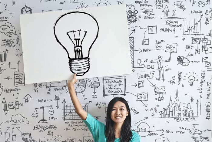A woman is holding up a large poster board with a sketch of a large lightbulb, in front of a white wall covered in math and comments.

(A crisis management plan means knowing what to do when everything starts to fall apart.)
